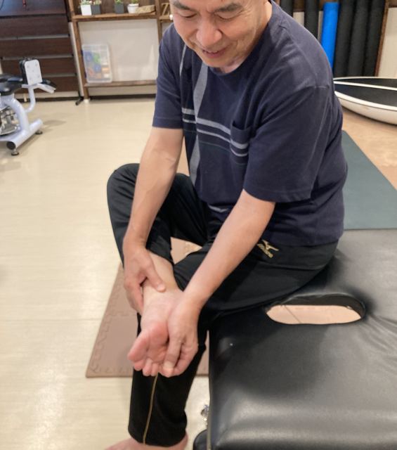 ベンチに座ったお客様が足首と足裏をほぐす様子