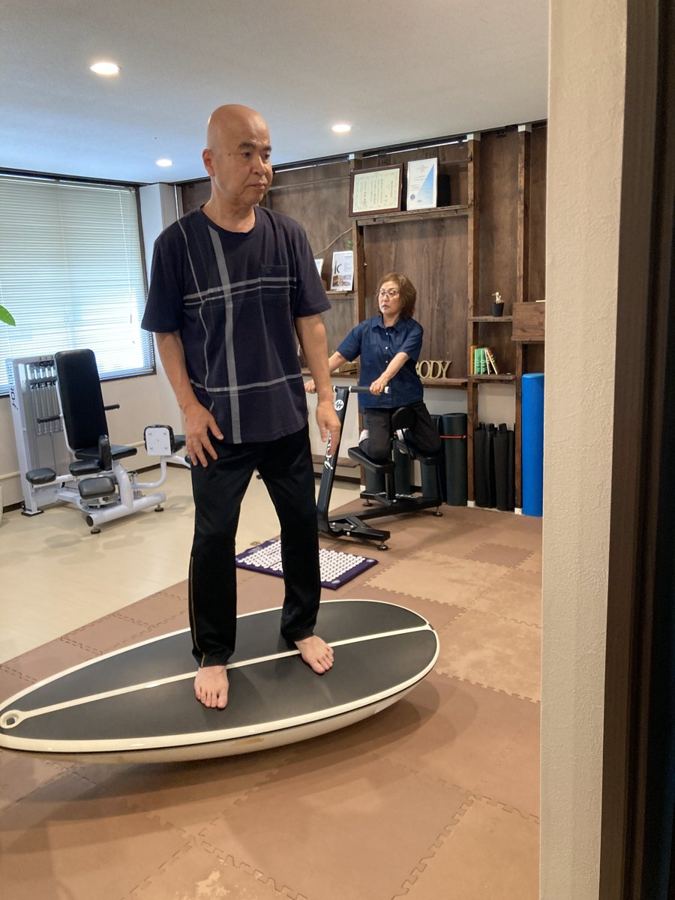 サーフトレーナーの上でバランスをとるシニアの男性